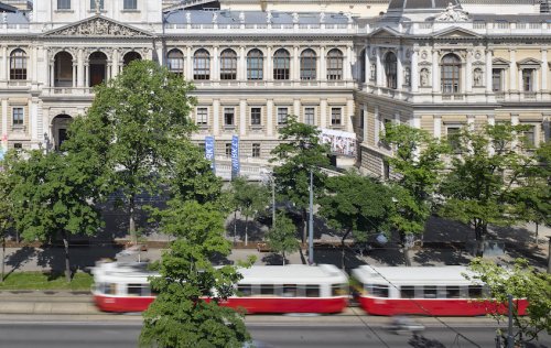 Teilansicht des Universitäts-Hauptgebäudes mit Straßenbahn im Vordergrund